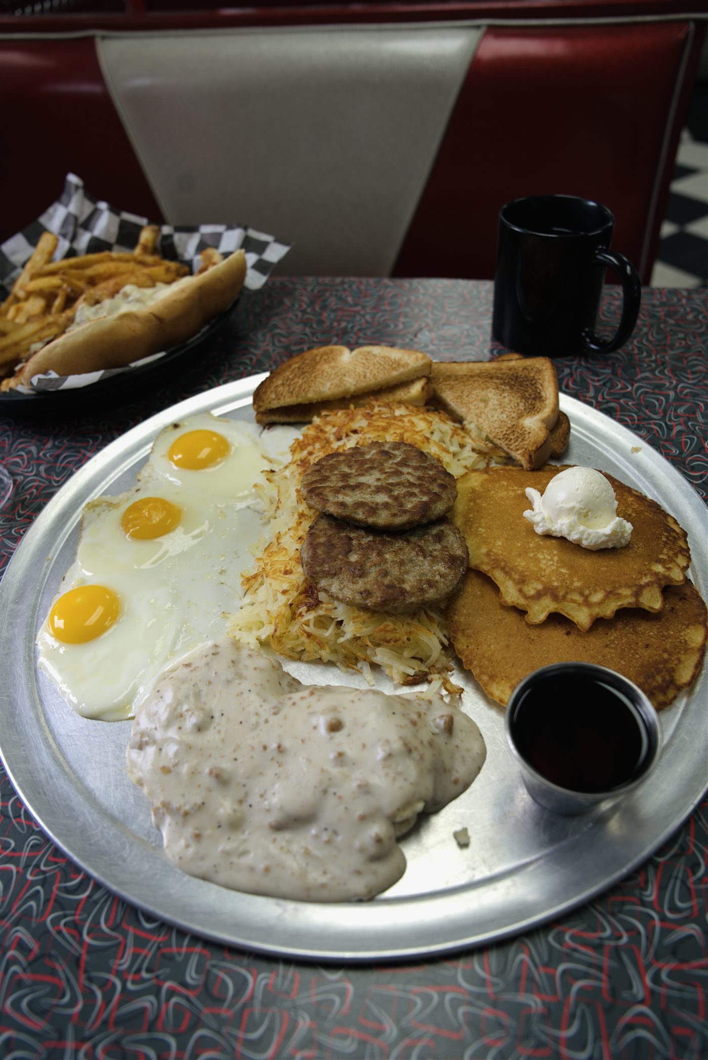 The legendary He-Man breakfast platter overflowing with eggs, sausage, bacon, hash browns, biscuit and gravy at The Lampost diner